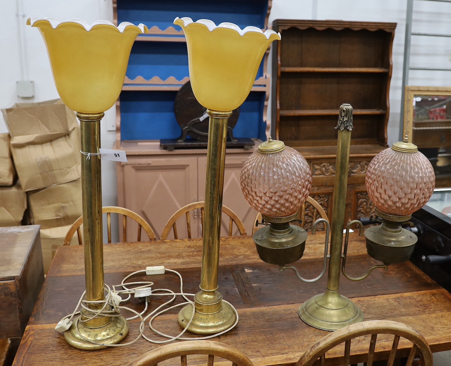 A pair of tall brass table lamps, height 65cm together with a brass two branch oil lamp with peach glass shades